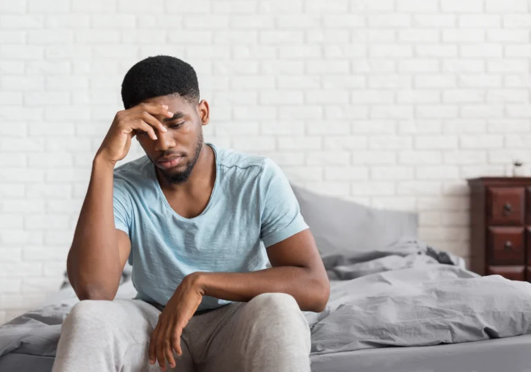 Teenager sitting on his bed looking sad