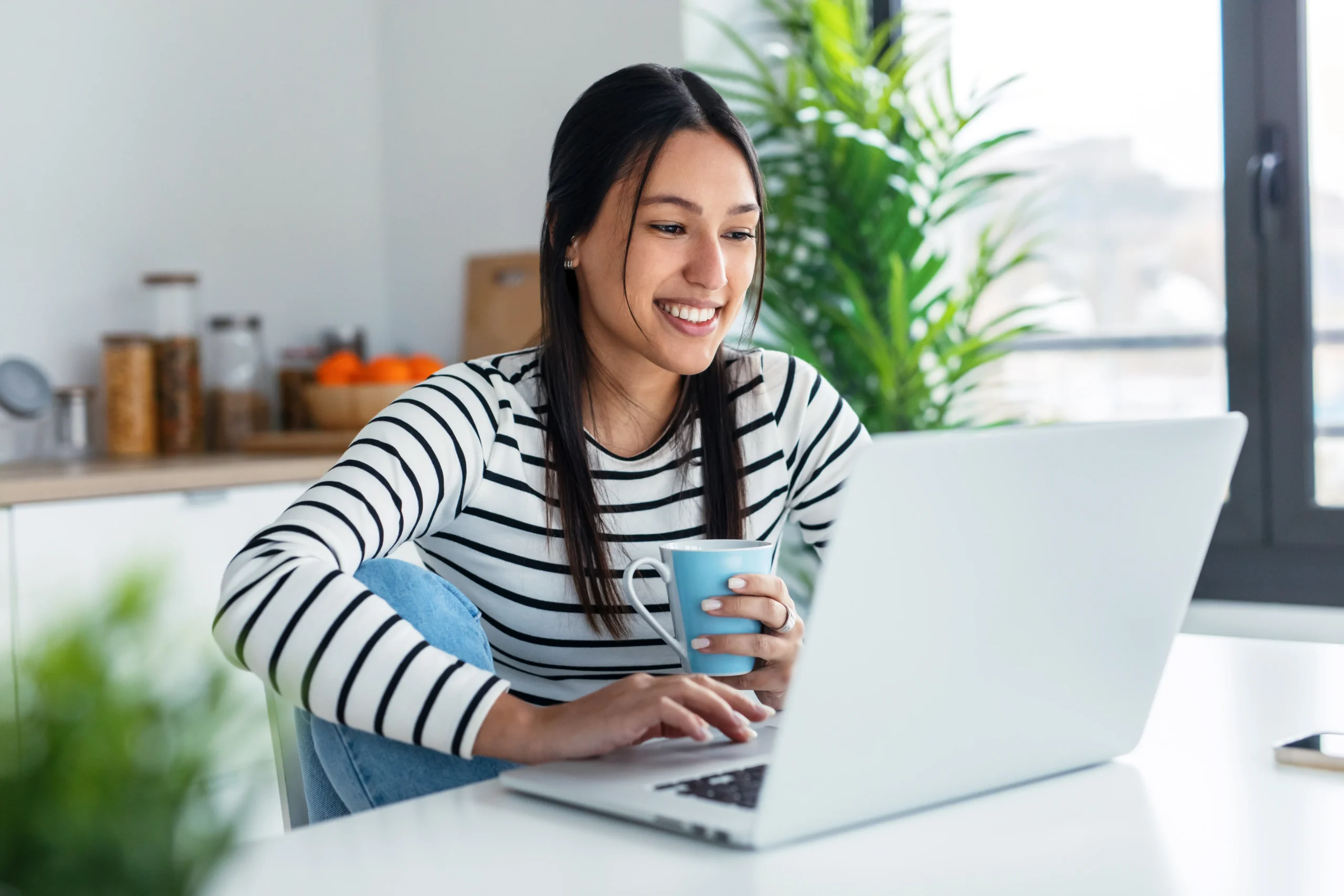 woman smiles while on her laptop