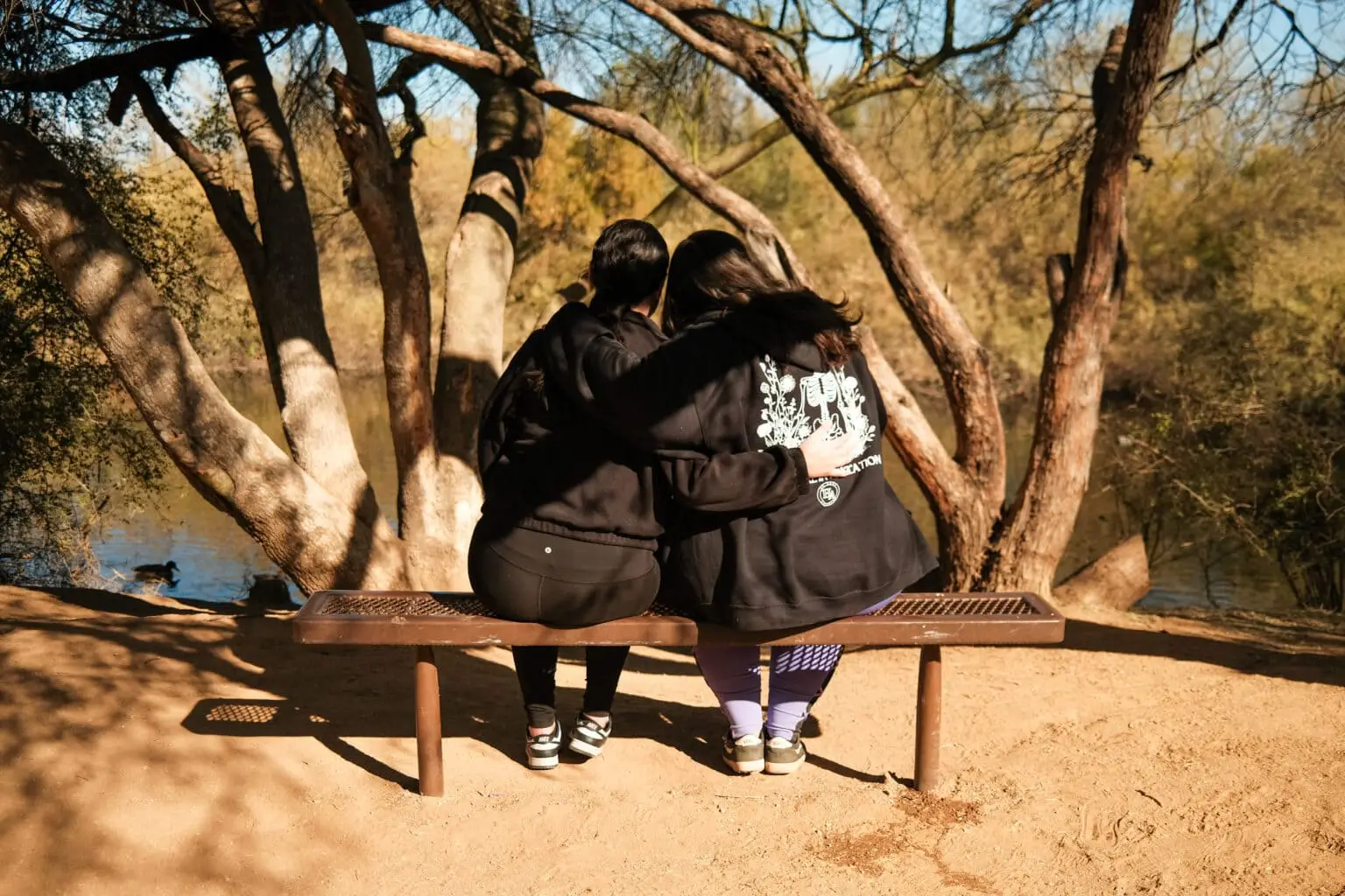 Two people on a bench hugging