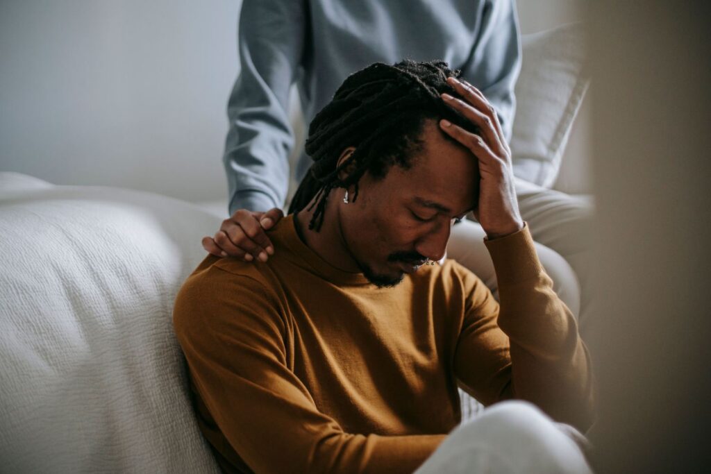 A man with depression being comforted