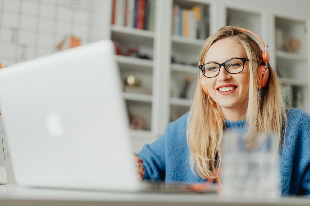 young woman smiling on her laptop while online with therapist