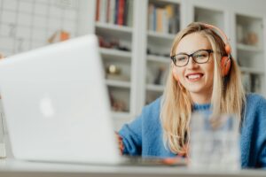 young woman smiling on her laptop while online with therapist