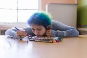 Depressed teenager at desk with head down
