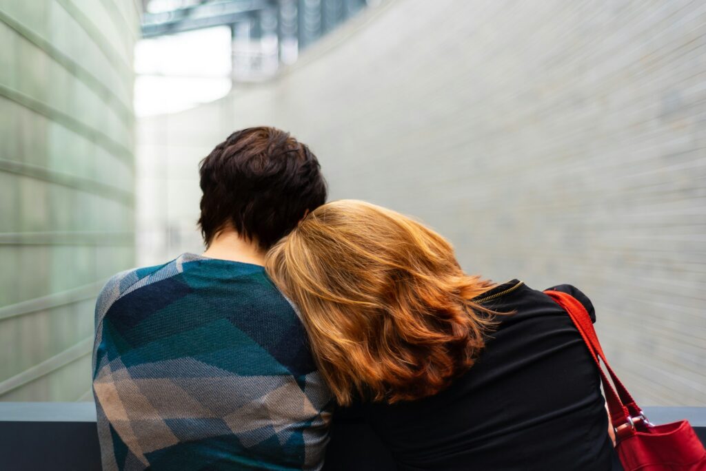 One person resting their head on another person's shoulder