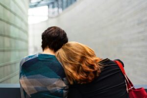 One person resting their head on another person's shoulder
