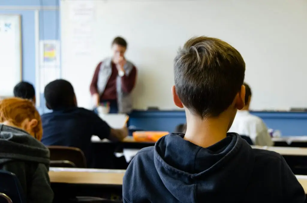 Teen student in classroom learning from teacher