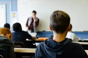 Teen student in classroom learning from teacher
