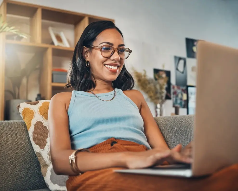 Woman sitting on couch with computer