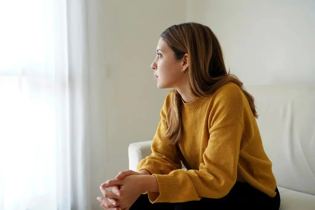 Woman in deep thought while sitting on a couch