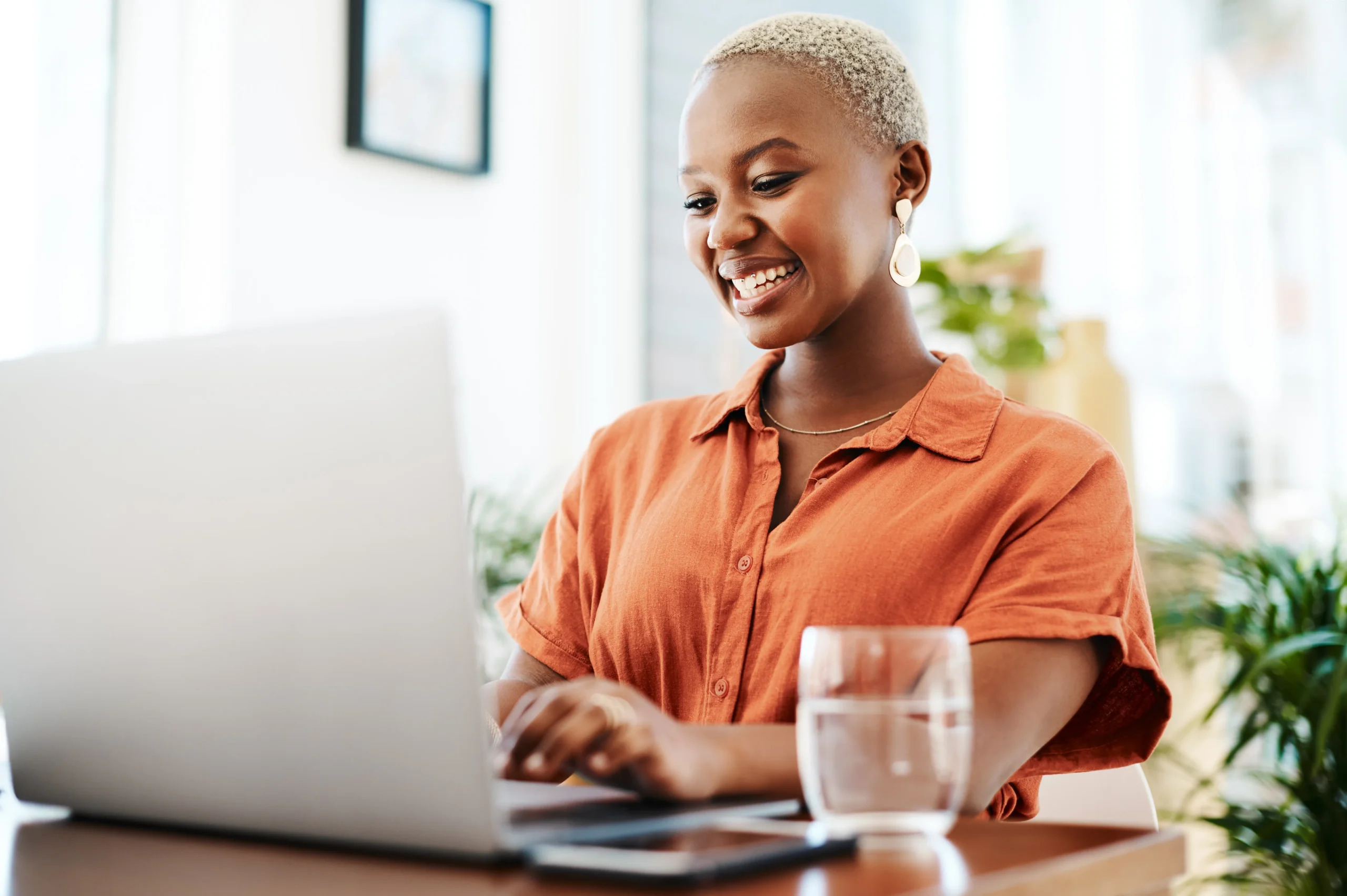 woman smiling at laptop while attending online therapy